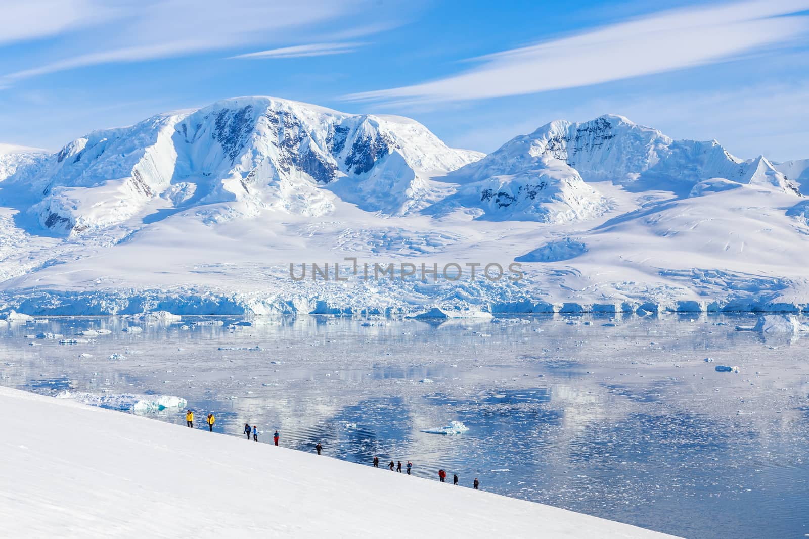 Group of people hiking the snowy mountains, Neco bay, Antarctic by ambeon