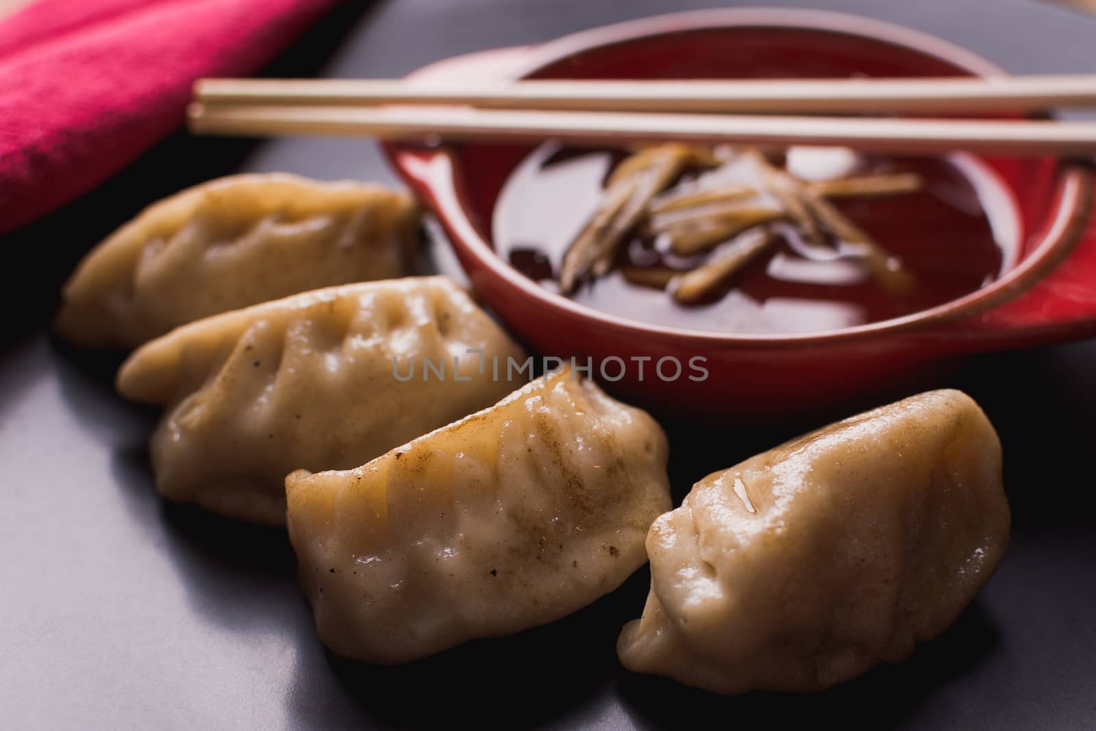 fried pork dumplings with a soy sauce and chopsticks