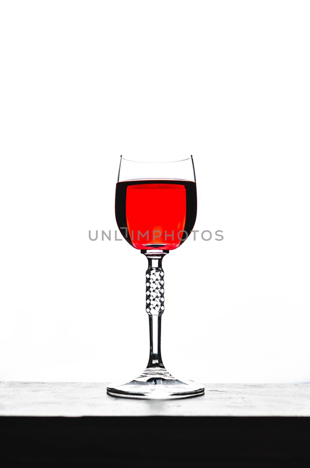 back lit sherry glass of red liquid, red wine