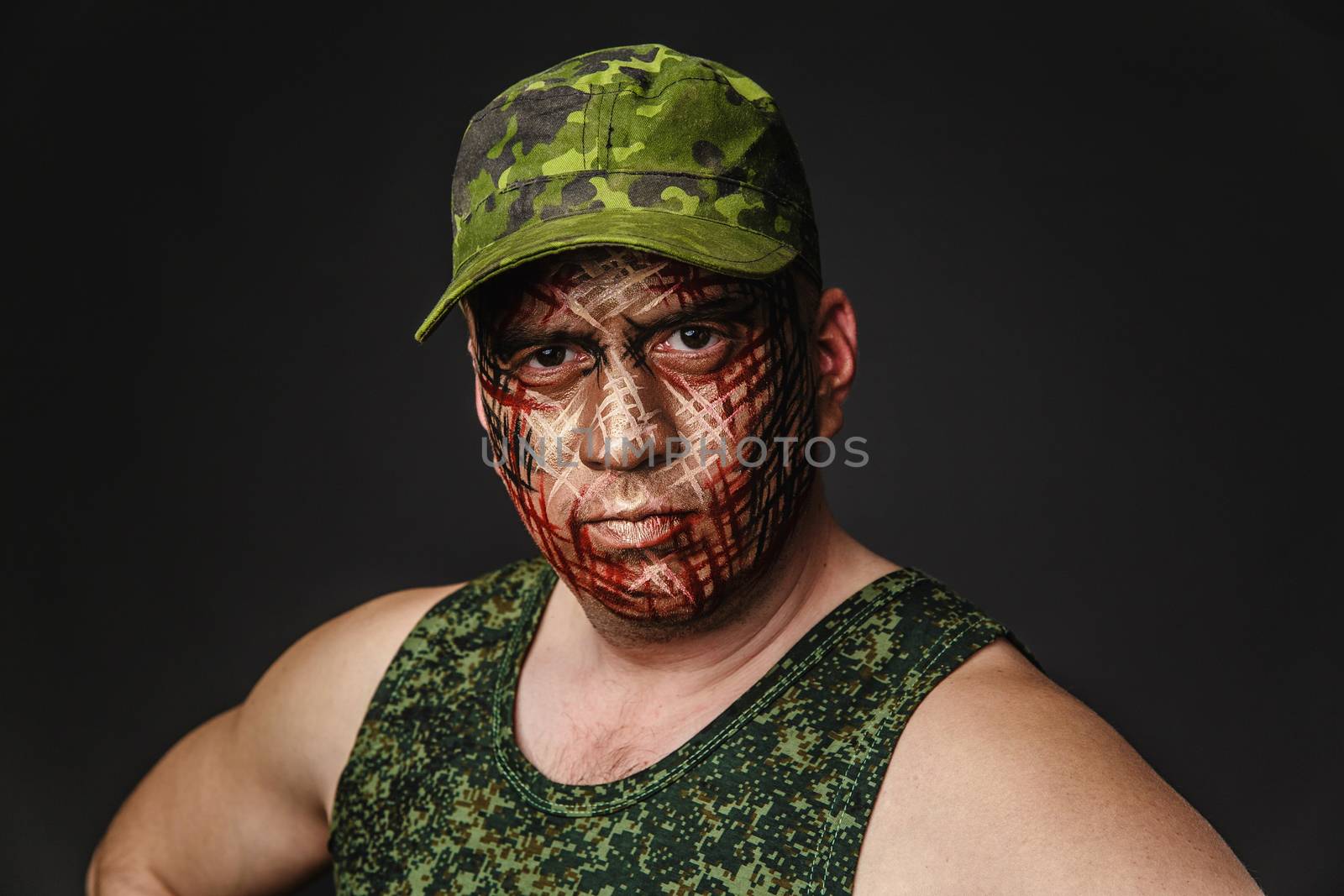 Portrait of Soldier with Military Style Camouflage on a  Face.  Portrait  on black background