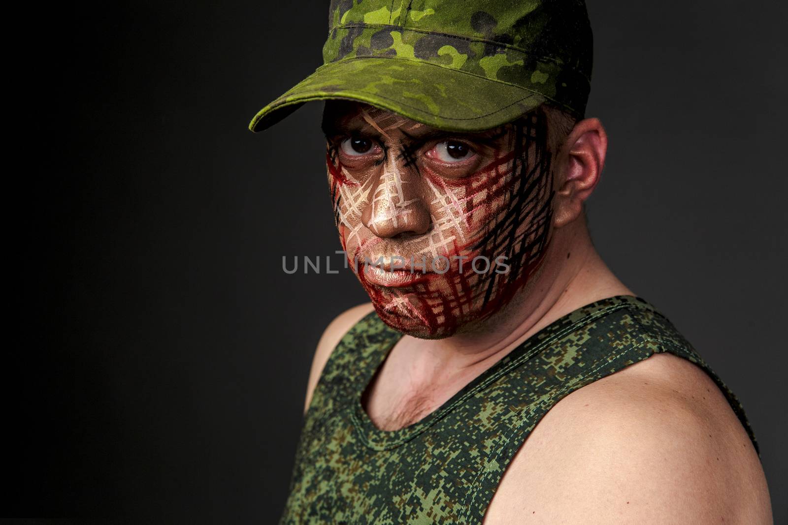 Portrait of Soldier with Military Style Camouflage on a  Face.  Portrait  on black background