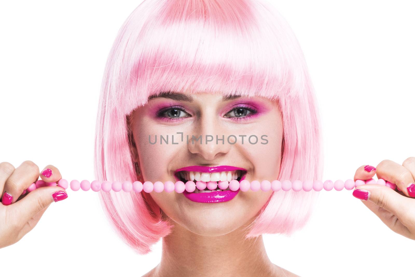 Portrait of girl with glamour make-up and pink hair biting beads isolated on white background