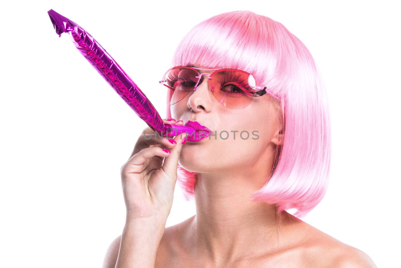 Portrait of girl with pink hair blowing in party whistle isolated on white background