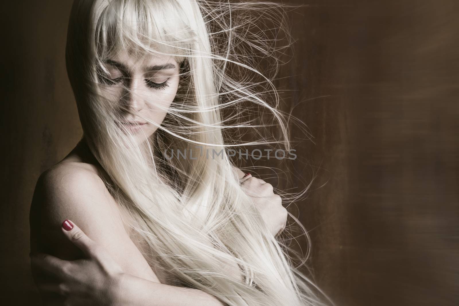 Studio portrait of beautiful sexy woman with long blonde flying hair