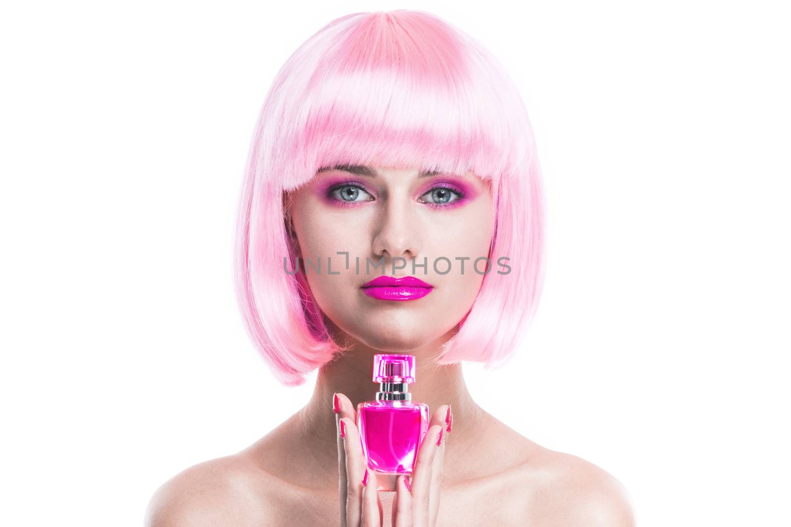 Portrait of girl with glamour make-up and pink hair holding perfume bottle isolated on white background