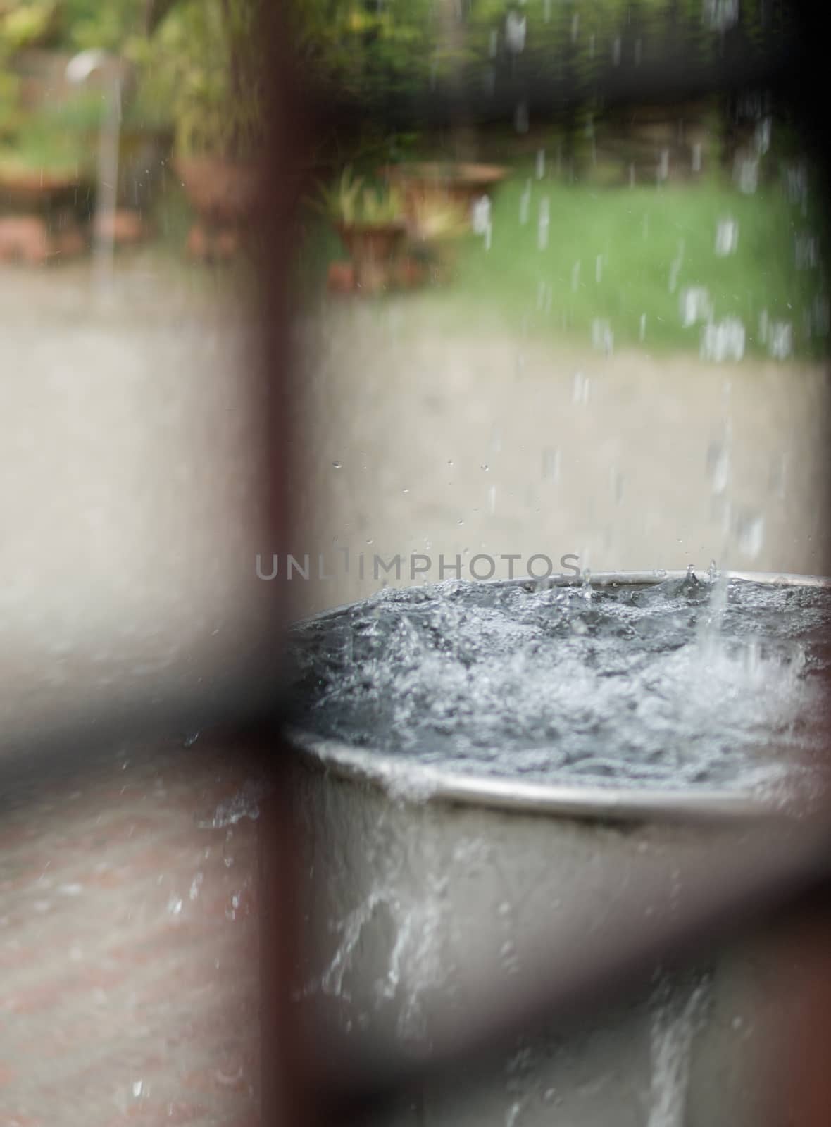 COLOR PHOTO OF RAIN DROPS FALLING INTO STEEL TANK