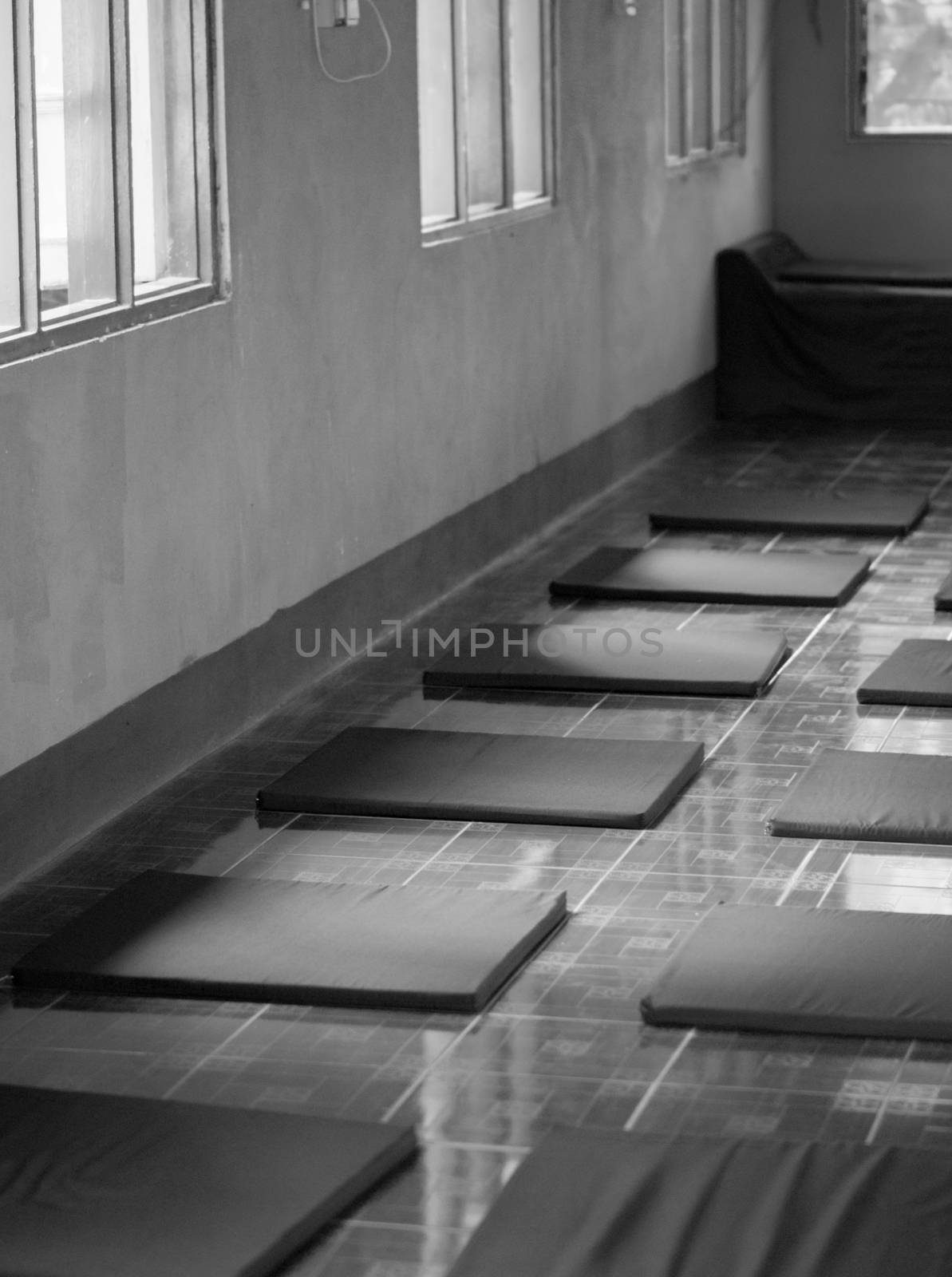 BLACK AND WHITE PHOTO OF ARRANGED MEDITATION CUSHIONS IN MEDITATION CENTER