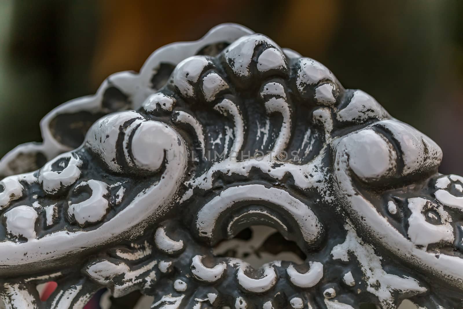 Pattern detail on a wrought iron bench in a park.