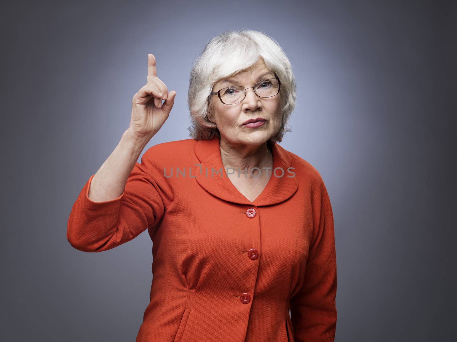 Senior lady points finger up by ALotOfPeople