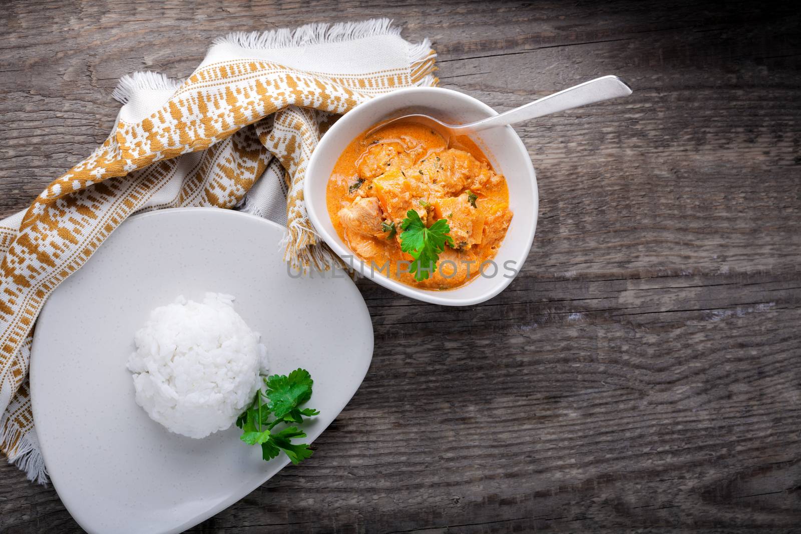 Chicken curry and rice served on a wooden surface