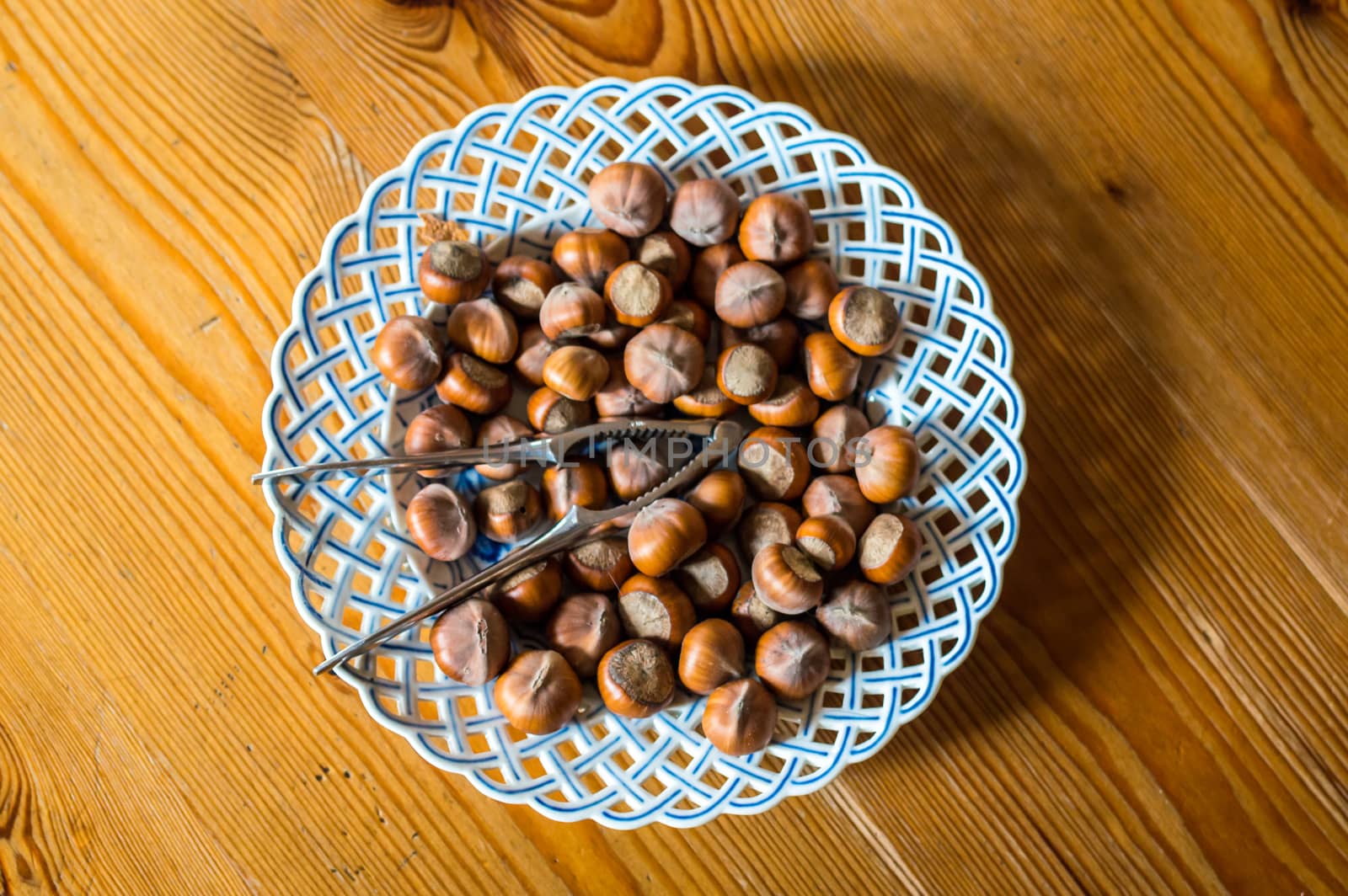 Close up hazelnut. Fresh organic filbert in plate on wooden background