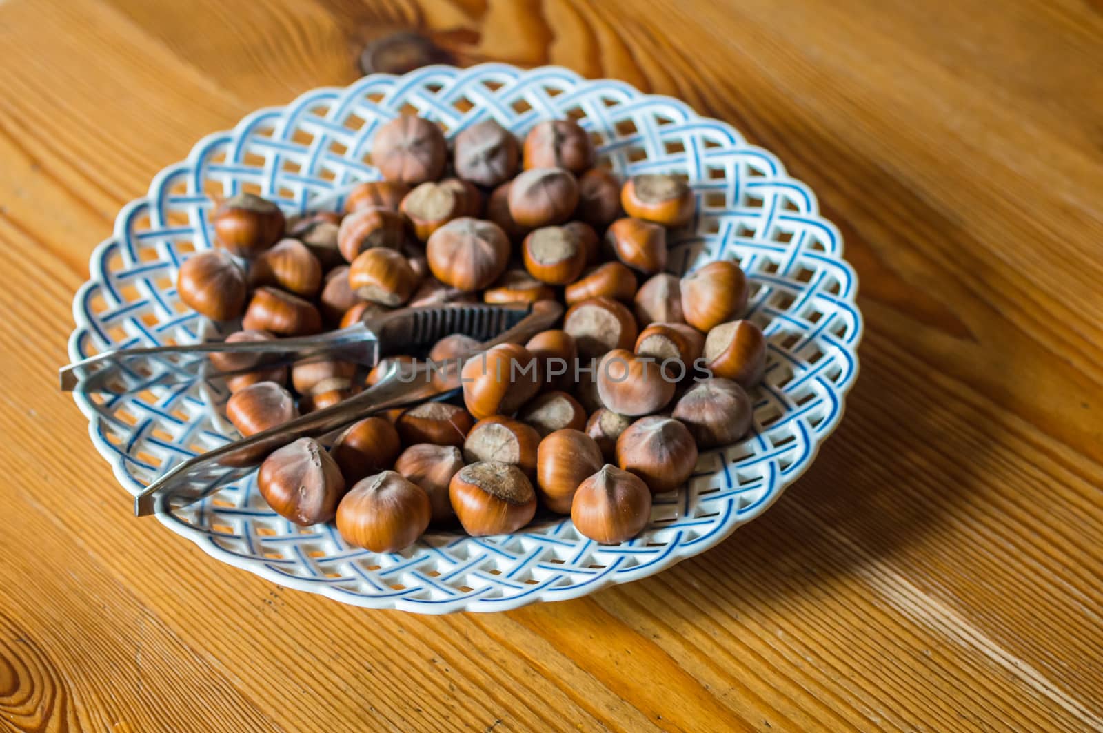 Close up hazelnut. Fresh organic filbert in plate on wooden background