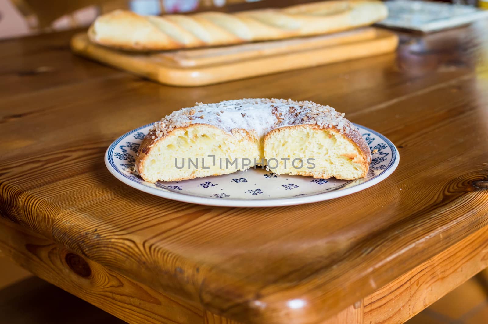 Close up brioche bread in a white plate on a wooden table. Baguette like fuzzy background