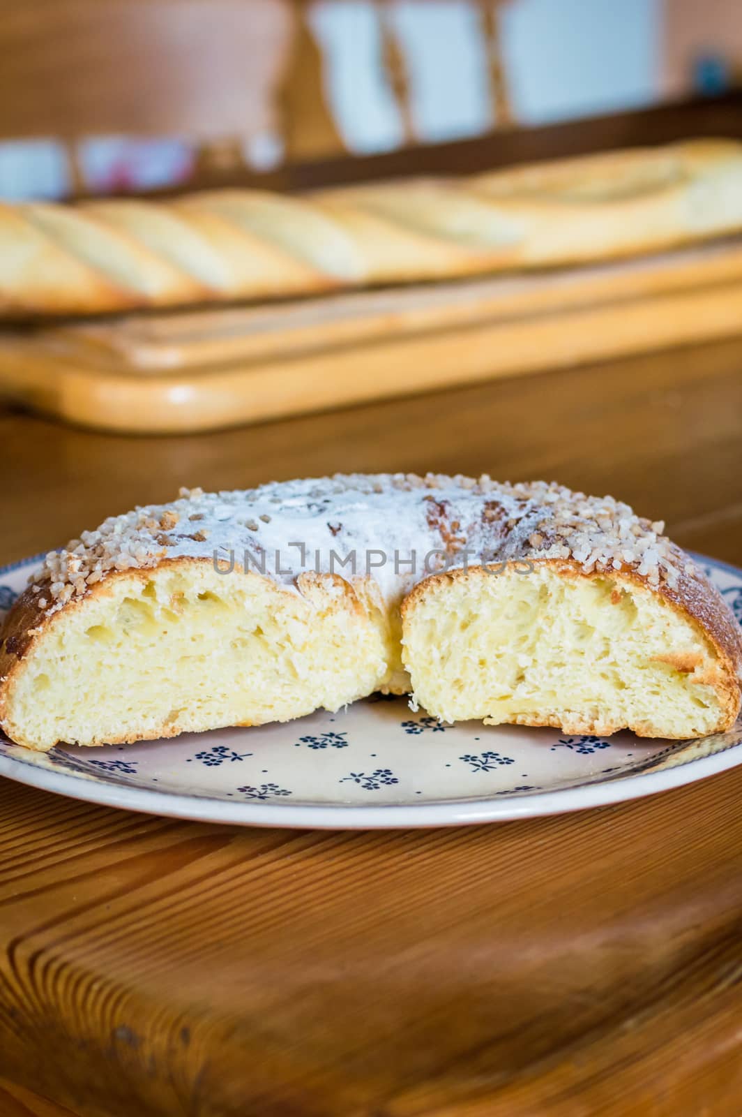 Close up brioche bread in a white plate on a wooden table. Baguette like fuzzy background