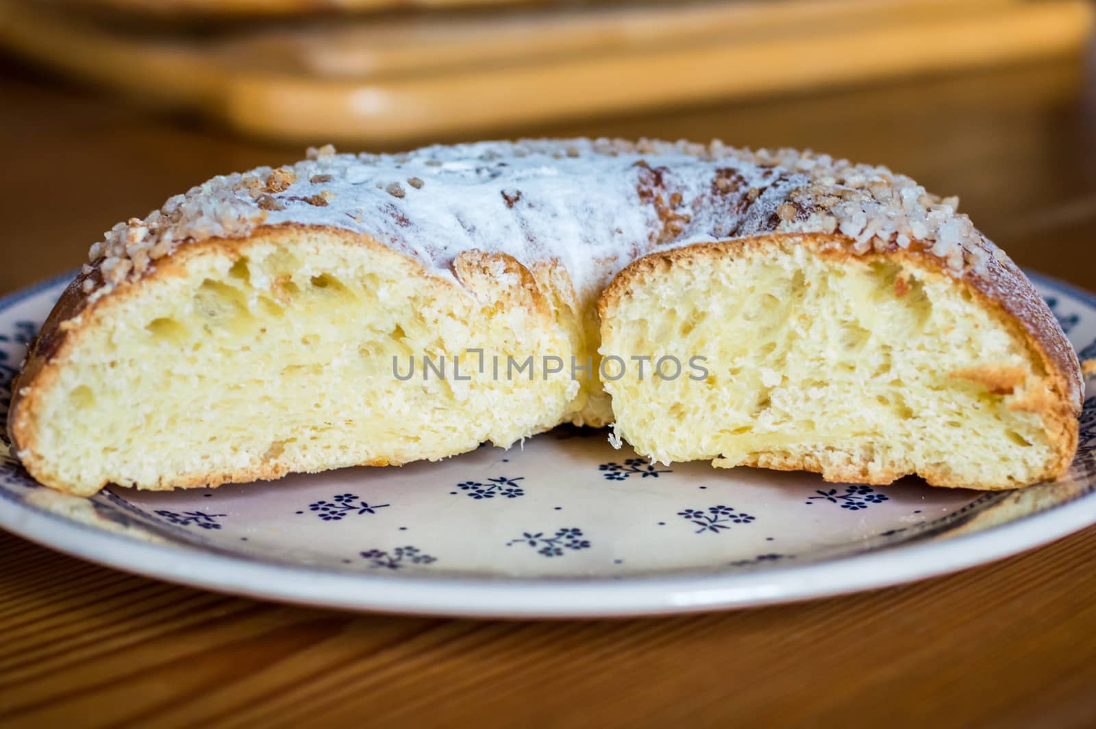 Close up brioche bread in a white plate on a wooden table. Baguette like fuzzy background