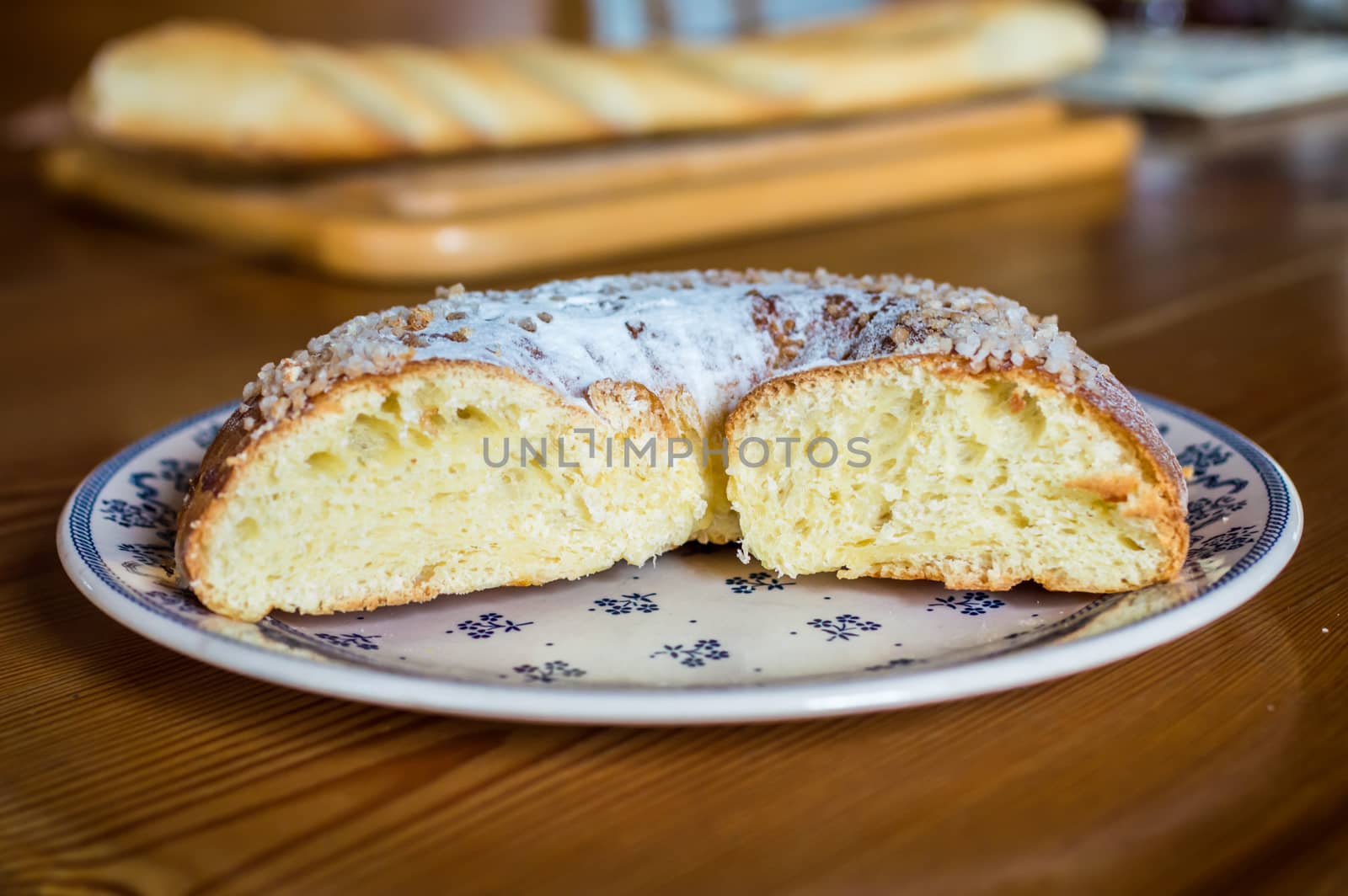Close up brioche bread in a white plate on a wooden table. Baguette like fuzzy background