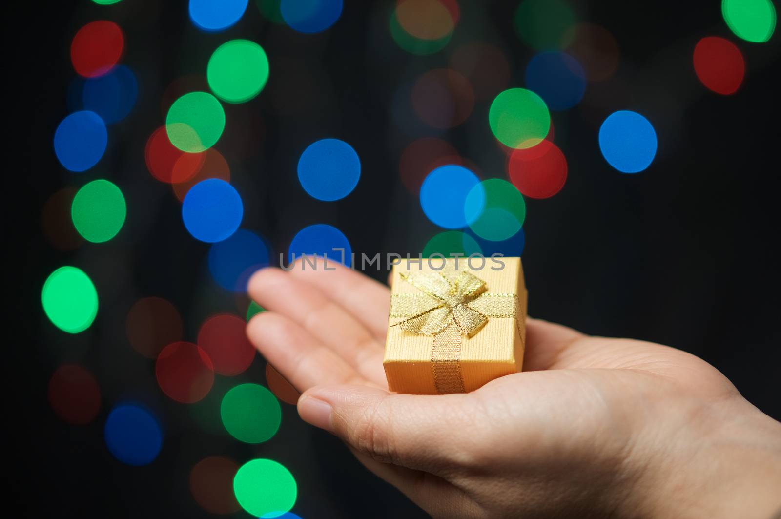 Gold present on hand of woman have bokeh as background by eaglesky