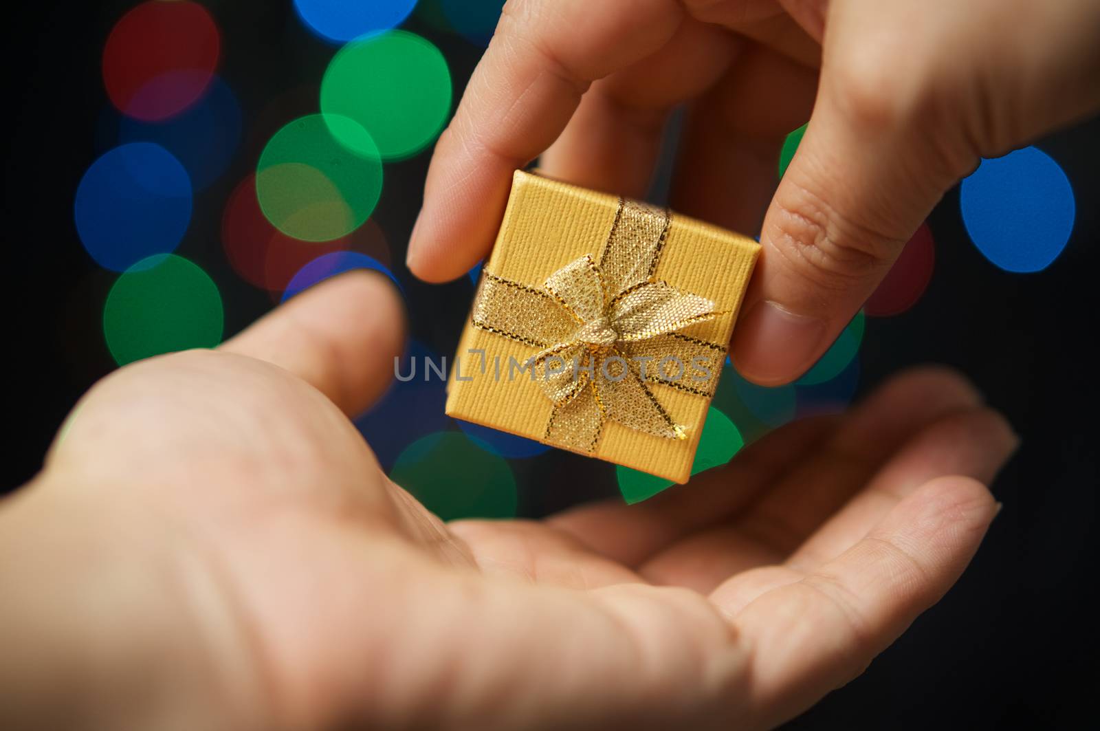 Hand of woman gift present have colorful bokeh as background by eaglesky