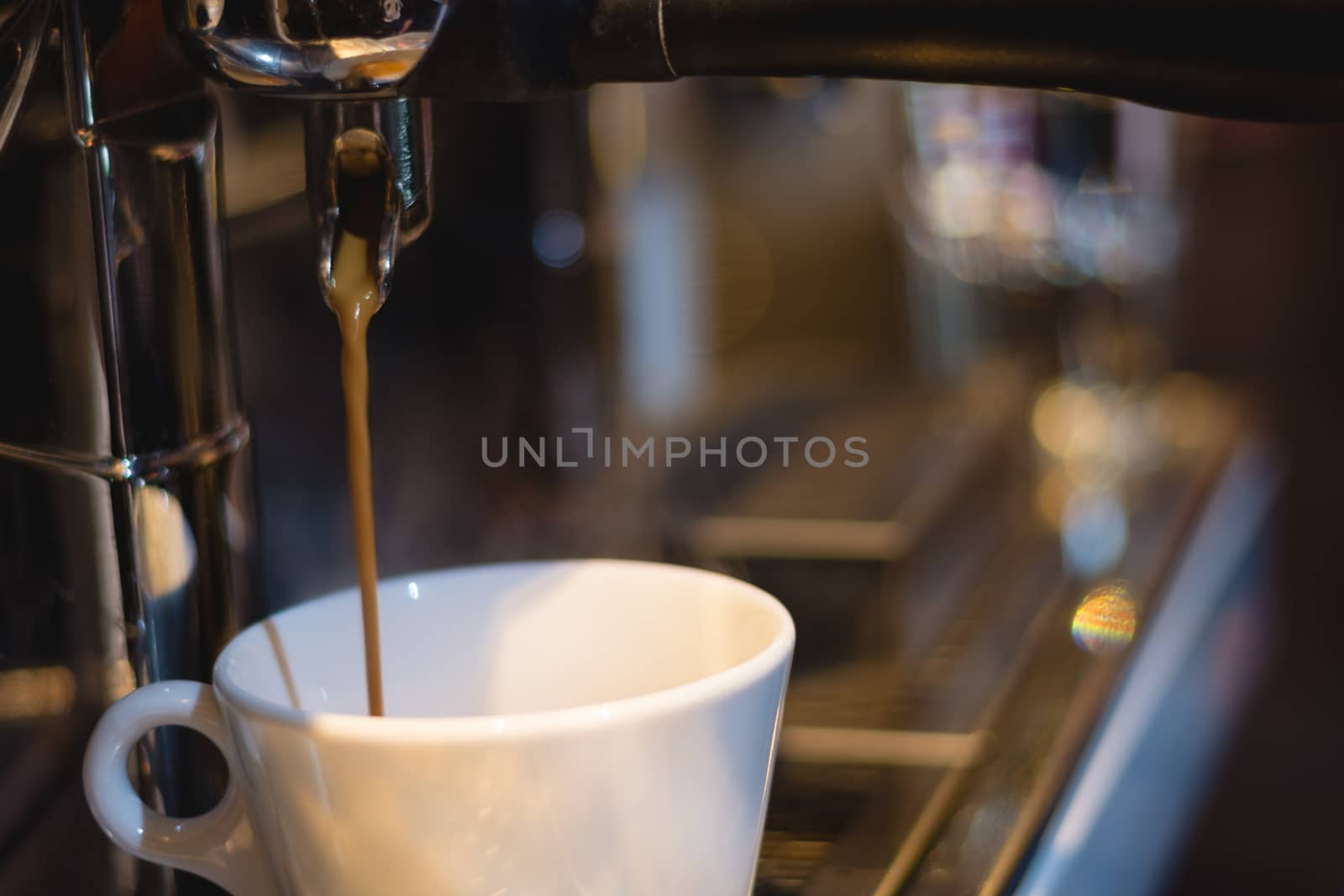 caramel coffee pouring from coffee machine into a cup in coffee shop