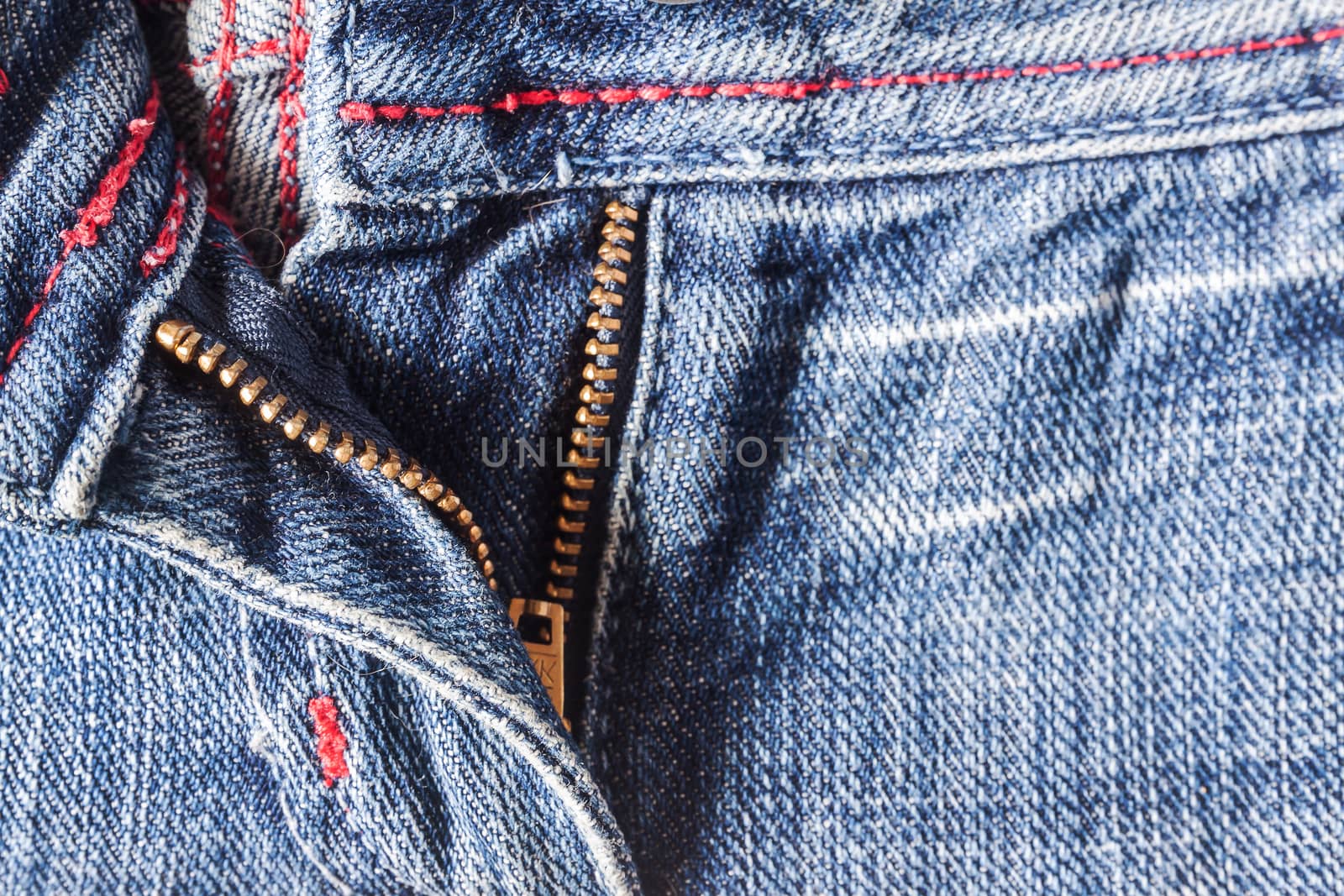 Denim pants to unfasten the zipper close-up by Tanacha