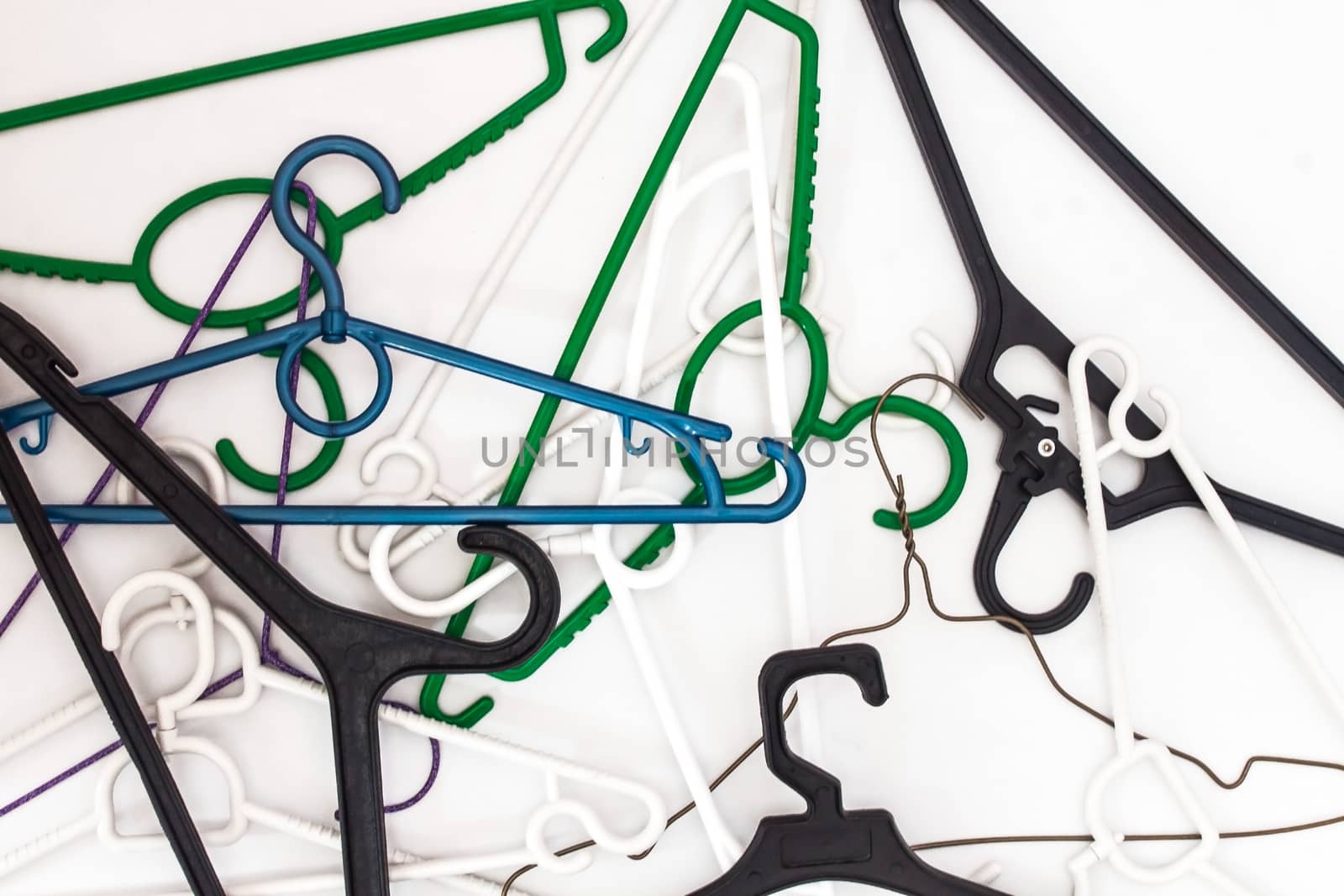 Many hangers of different shapes and colors, top view, white background.