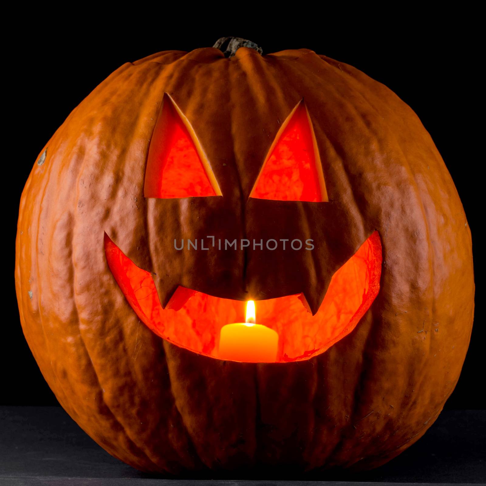 Funny glowing Halloween pumpkin isolated on a black background