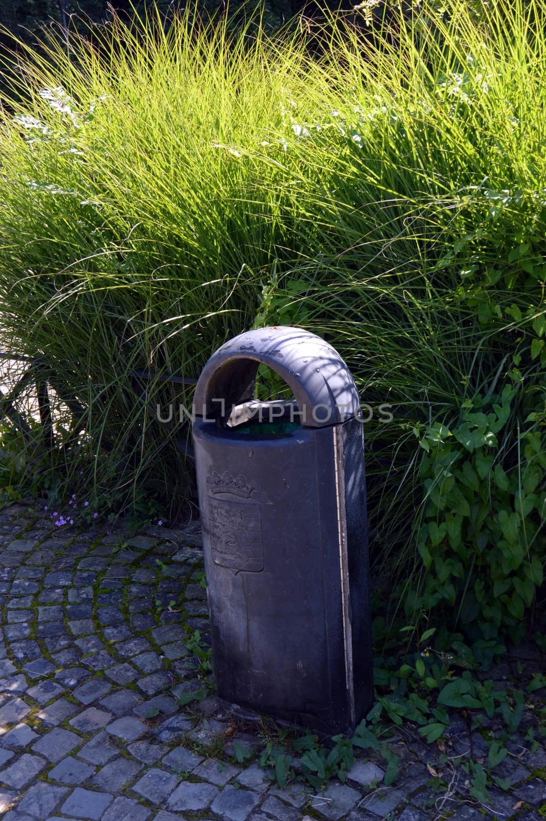 Tub trash can on a picket in the forest.