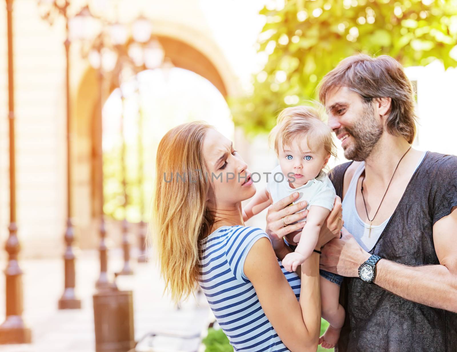 A young family couple with their cute little baby boy outdoors.