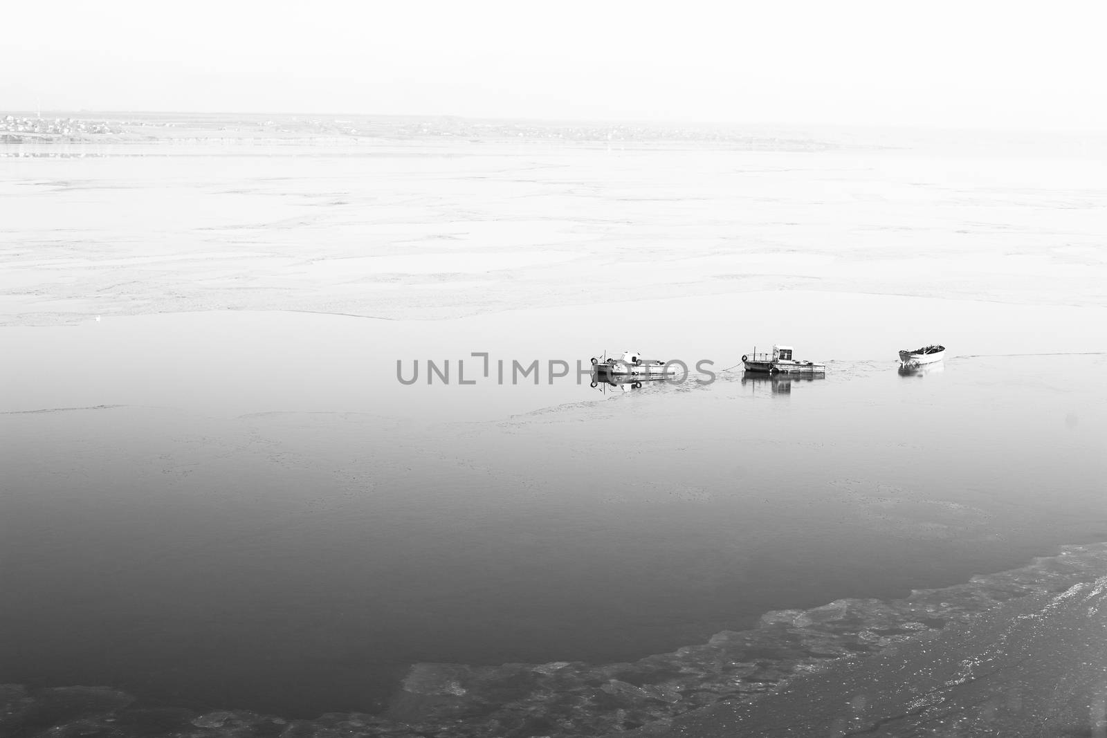 A few small ships in the winter sea near coast black and white photo