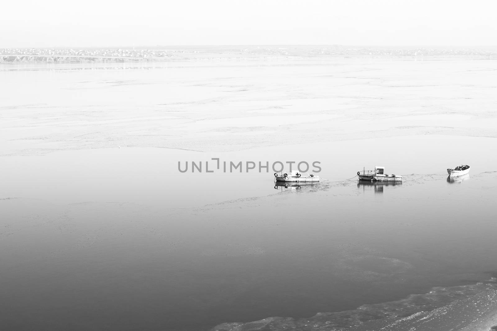 A few small ships in the winter sea near coast black and white photo