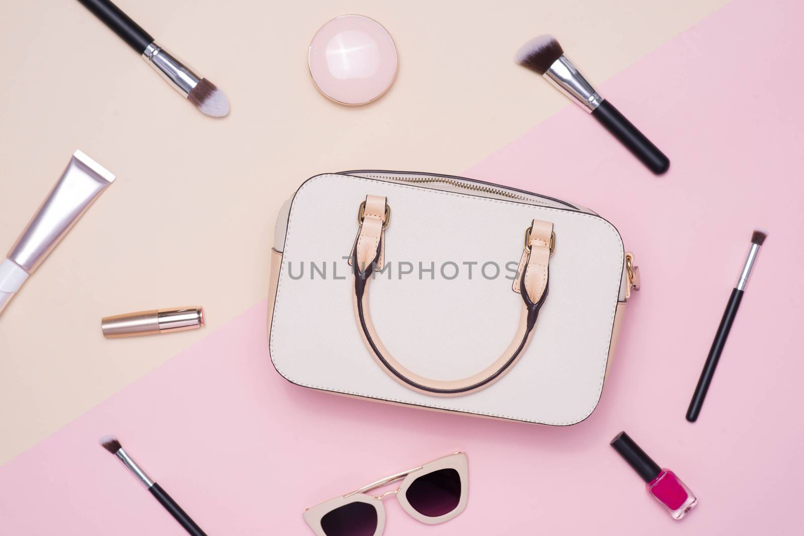 Flat lay of female fashion accessories and white handbag on pastel color background with copyspace