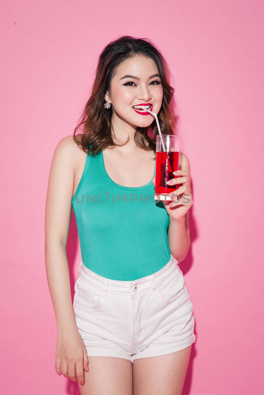 Celebrating asian girl with professional makeup and stylish hairstyle holding a glass of champagne.