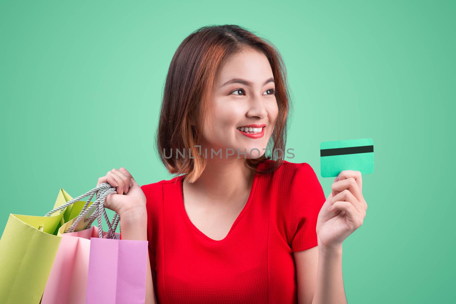 Young asian girl with credit card and shopping bags by makidotvn