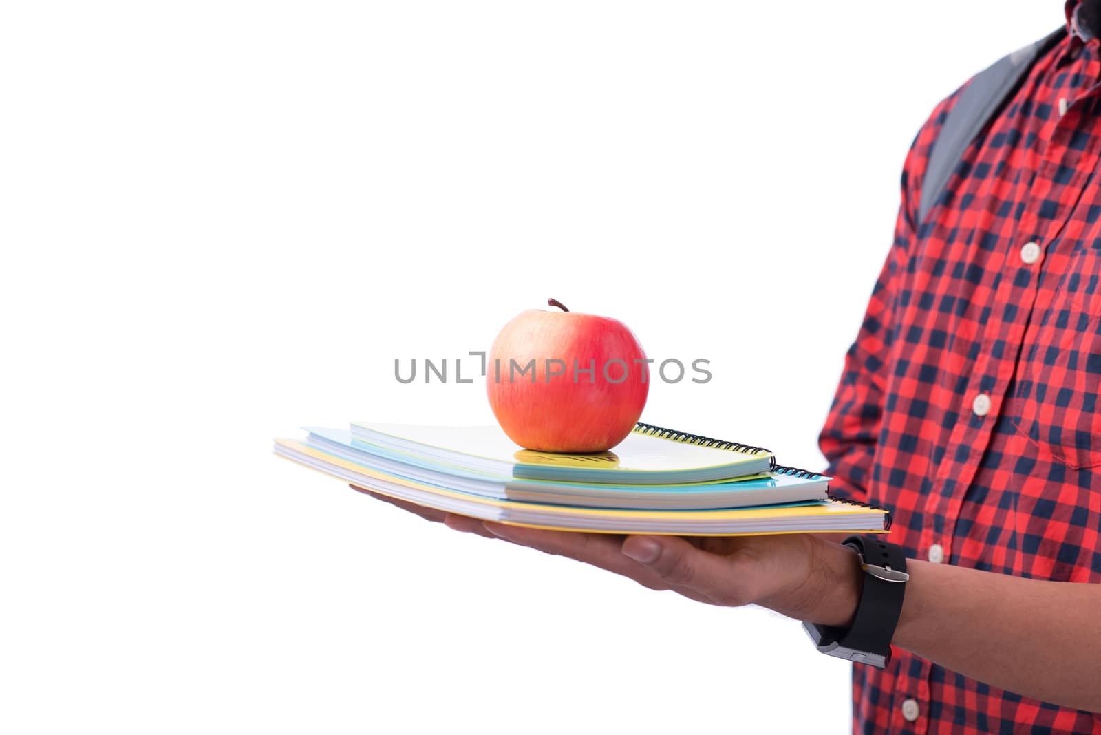 Hands holding red apple with book, isolated on white.