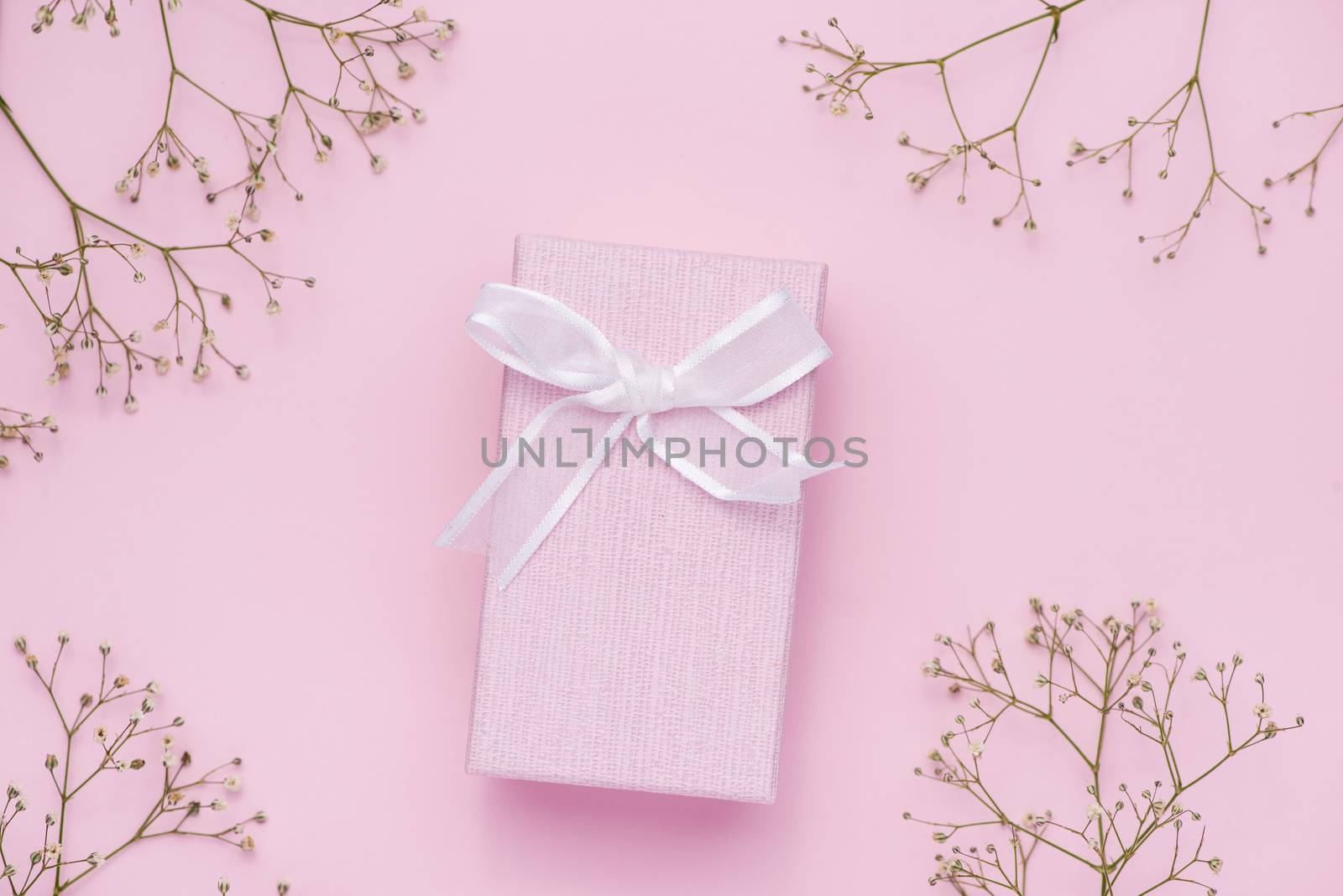 Gift box tied with pink ribbon and white flowers for mothers day by makidotvn