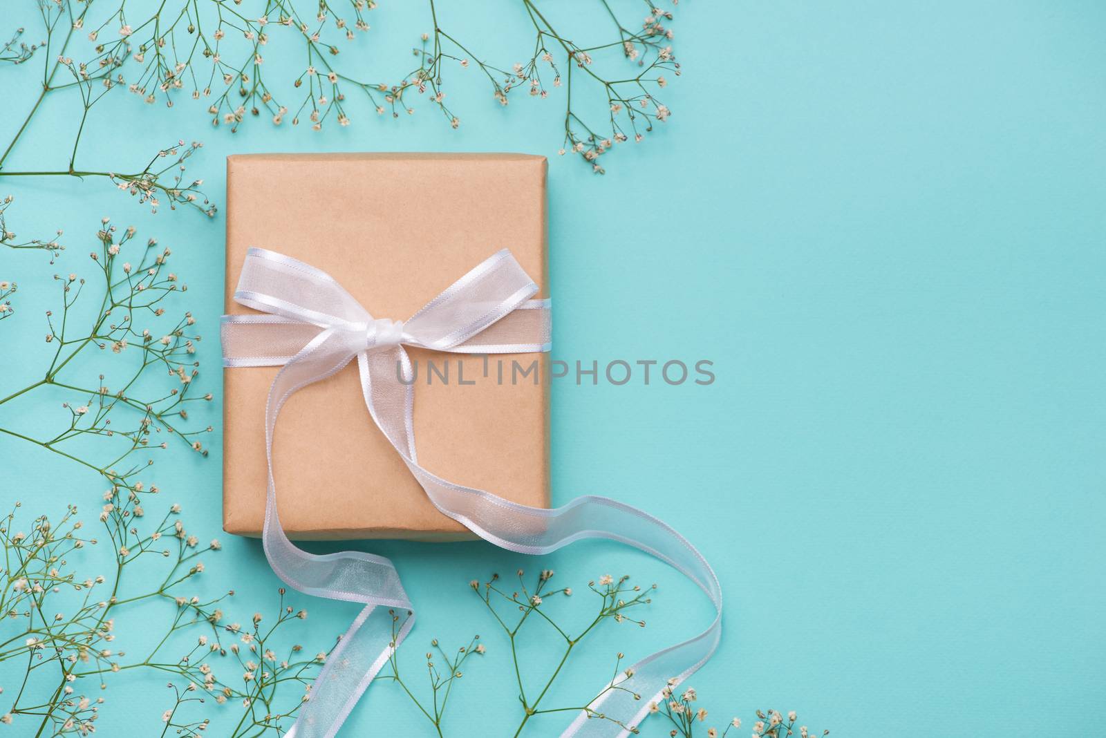 Kraft paper gift box tied with white ribbon and flowers for mothers day