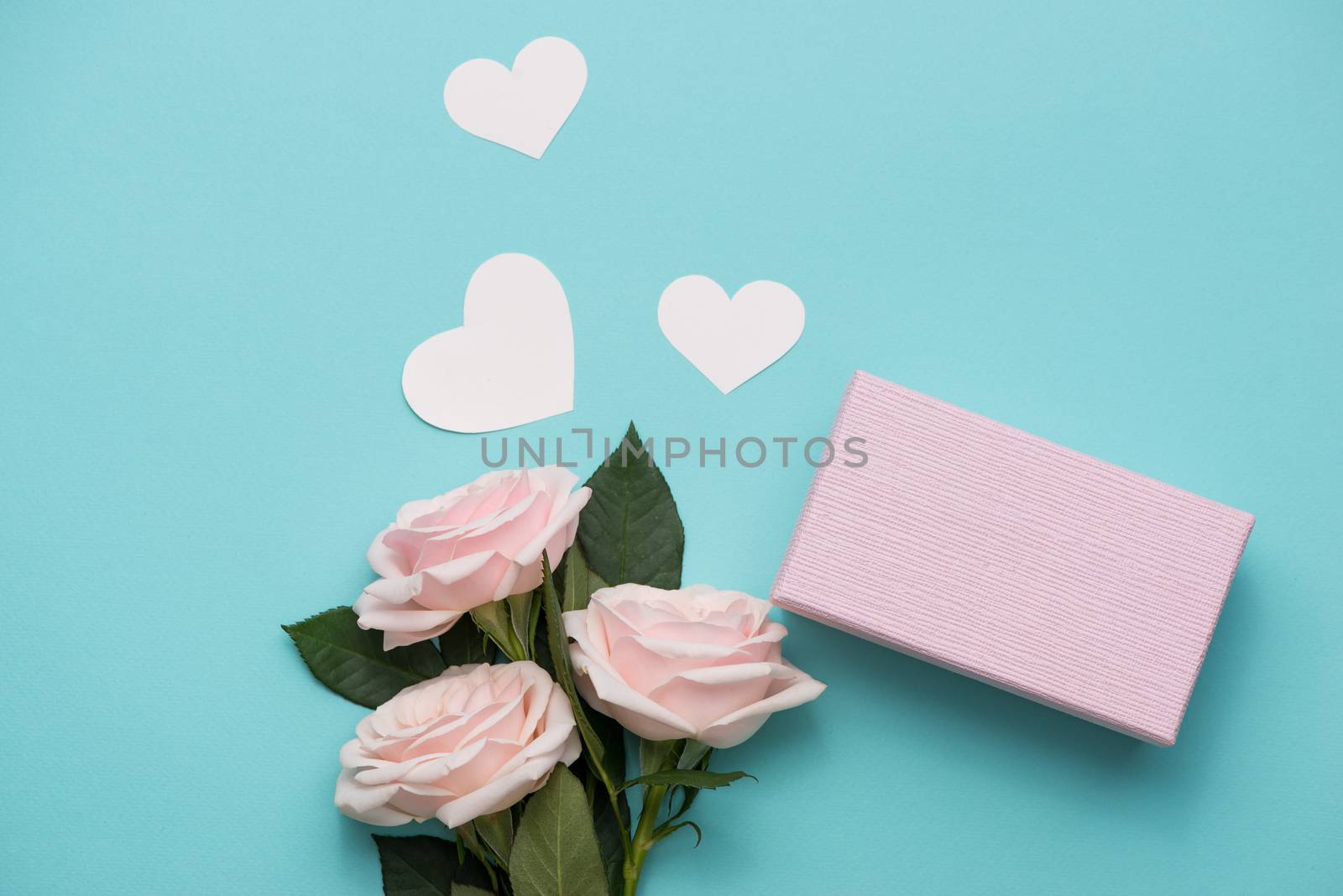 Mother's Day concept. Pink roses with gift box. Open notebook for copy space.