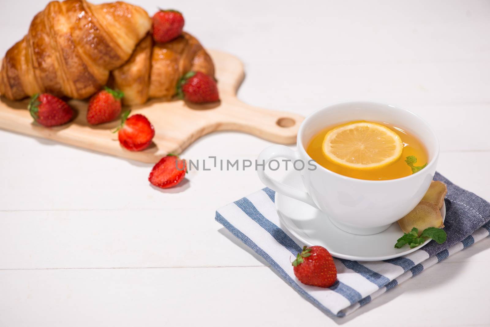 Healthy ginger tea with morning breakfast on a wooden table