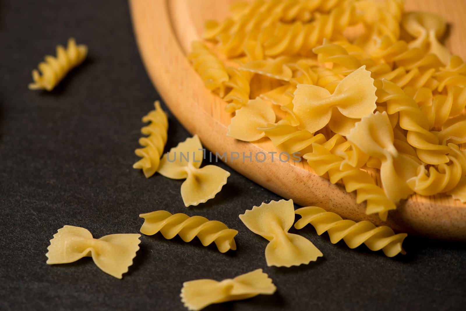 Variety of types and shapes of dry Italian pasta on dark backgro by makidotvn