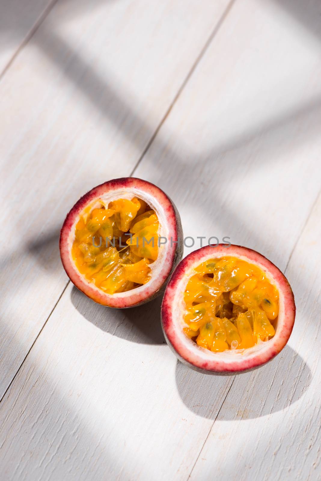 Half of passion fruit on wooden table. by makidotvn