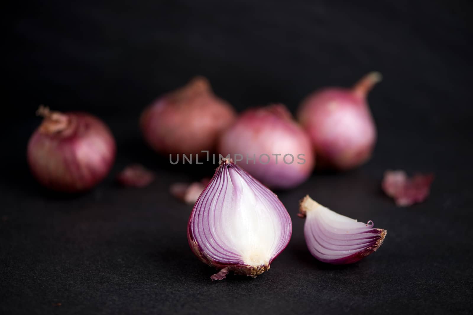 Full and half cut spanish onions on dark background. by makidotvn