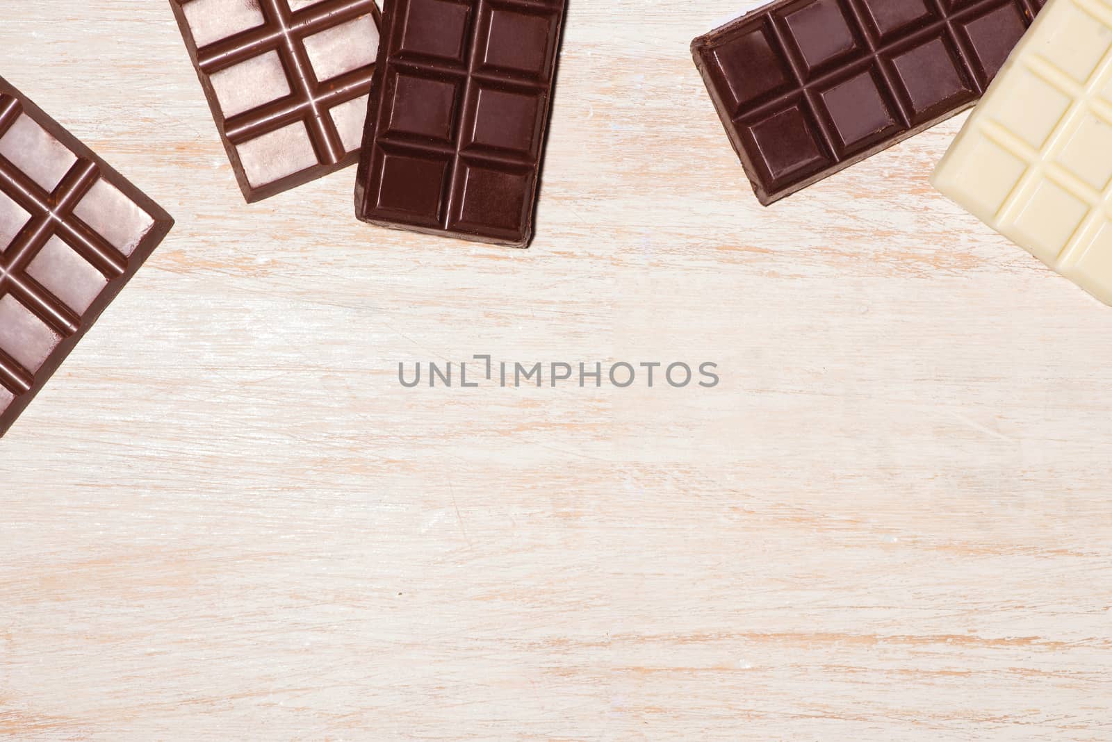A lot of variety chocolates bar in box on white wooden background