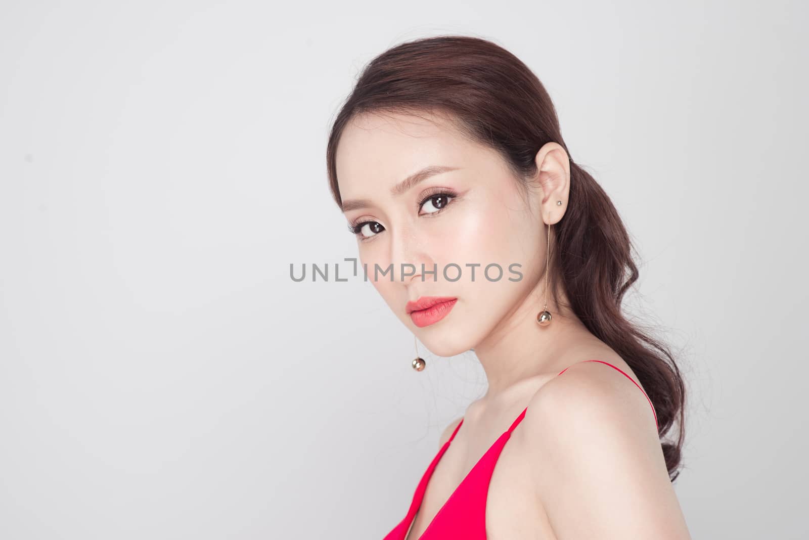 Beautiful stylish asian woman wearing red dress on grey backgrou by makidotvn