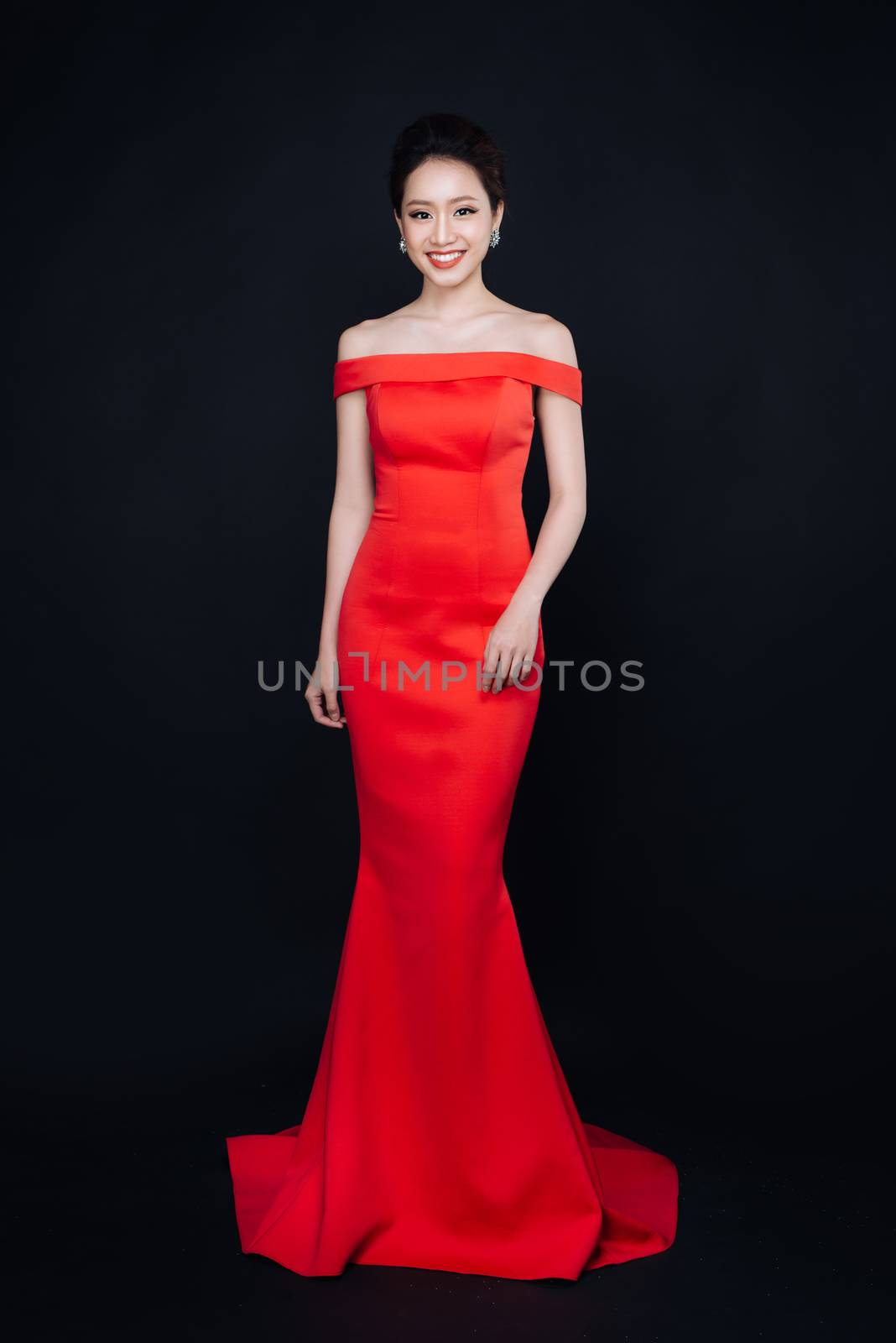 Asian woman with fashion makeup in luxury red dress.