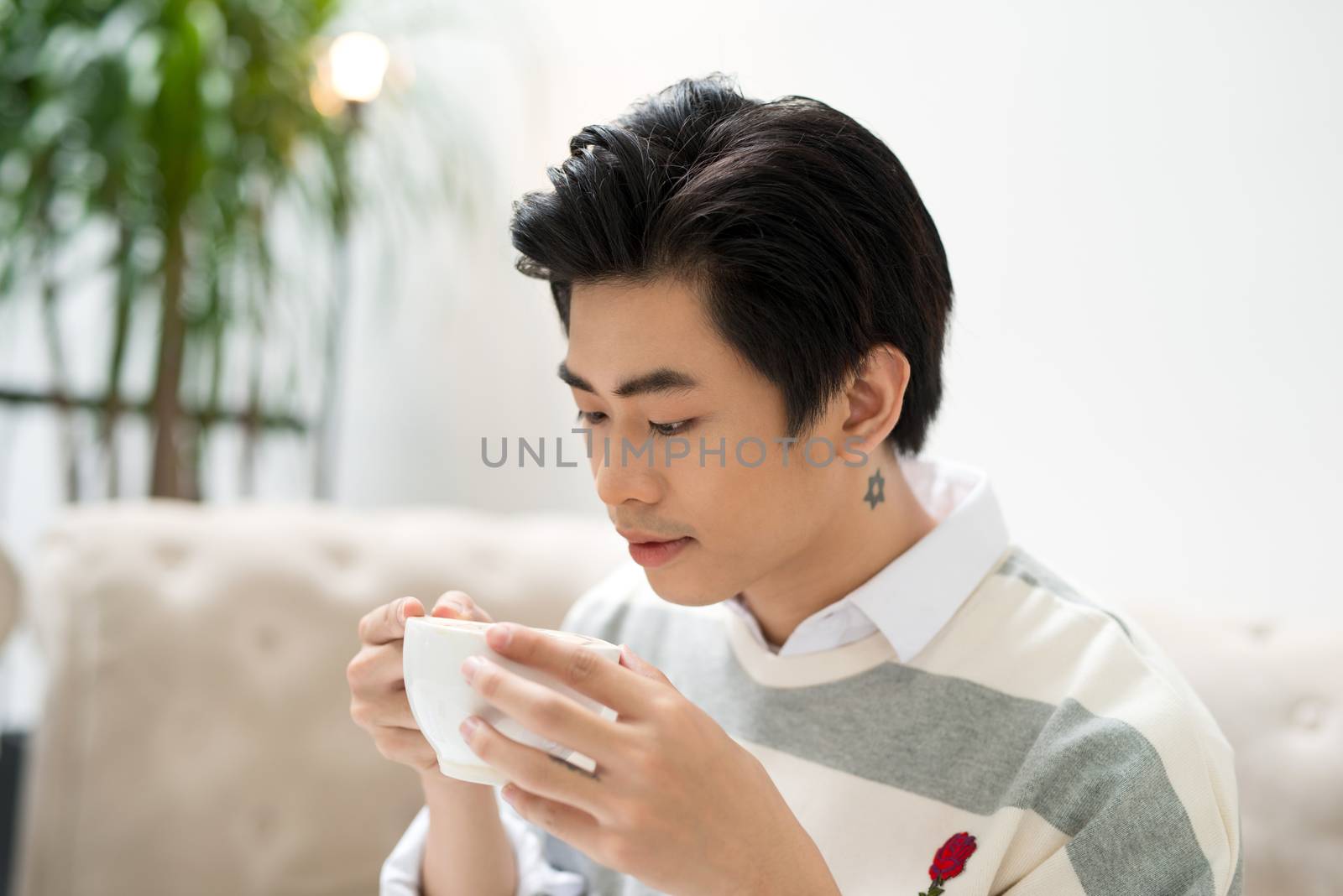 Asian businessman using mobile phone  during coffee break on tab by makidotvn