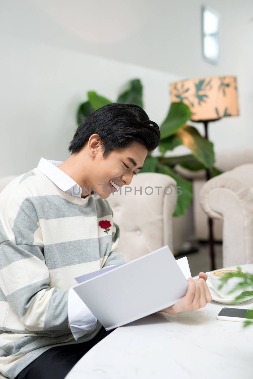 Asian entrepreneur reading book during coffee break