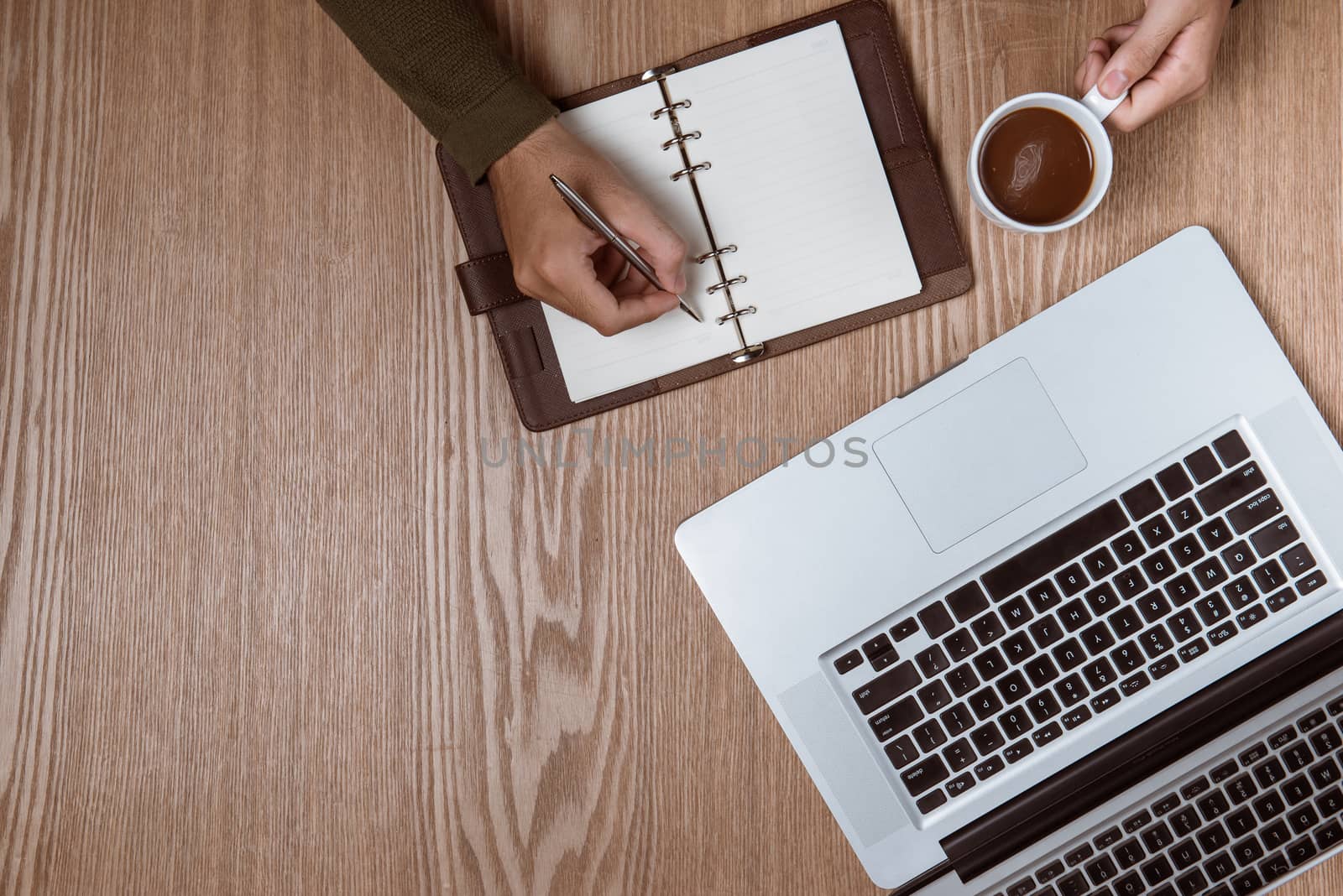 Business man hands using a laptop with a cup of coffee and smart phone with copy space.