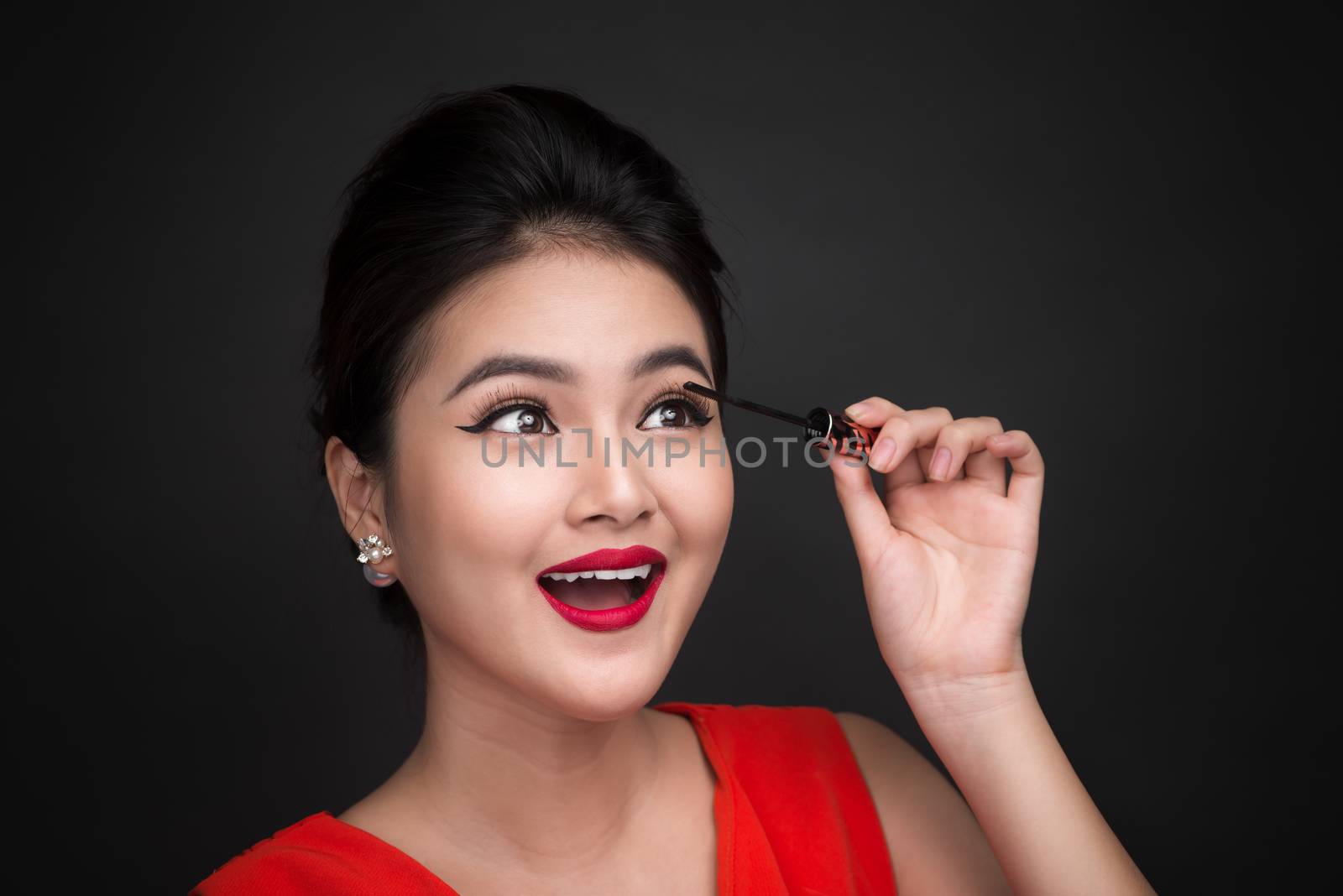 Make-up and cosmetics concept. Asian woman doing her makeup eyelashes black mascara.
