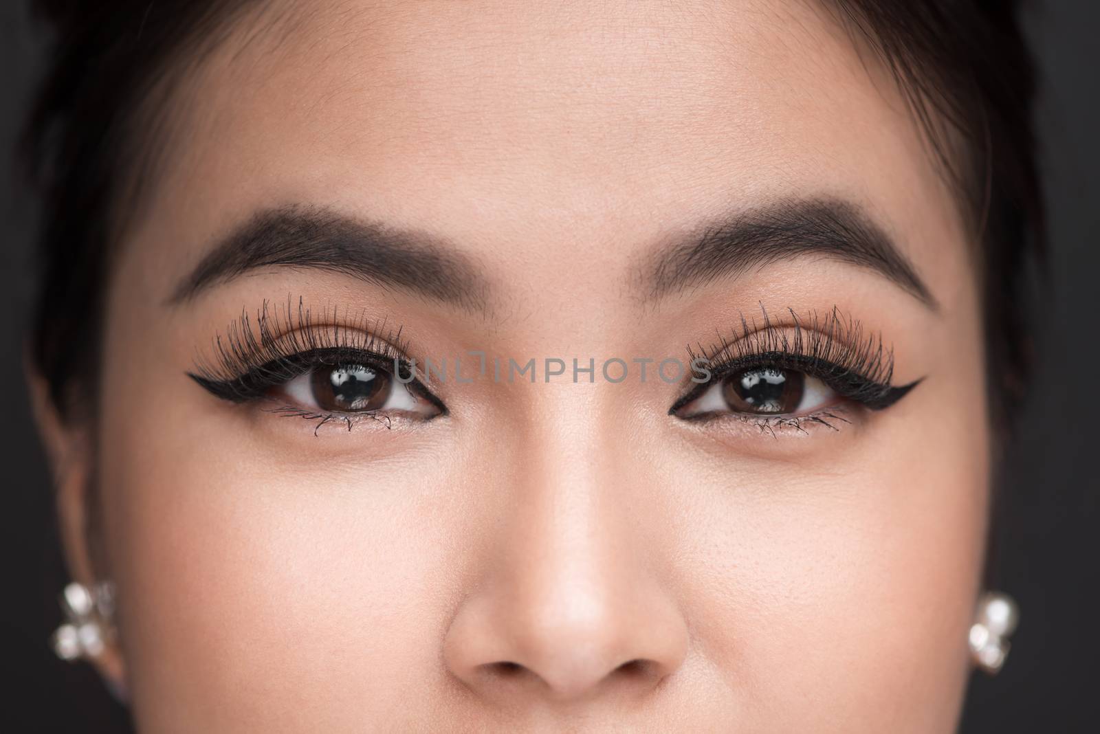 Perfect shape of eyebrows. Beautiful macro shot of female eye with classic eyeliner makeup. 