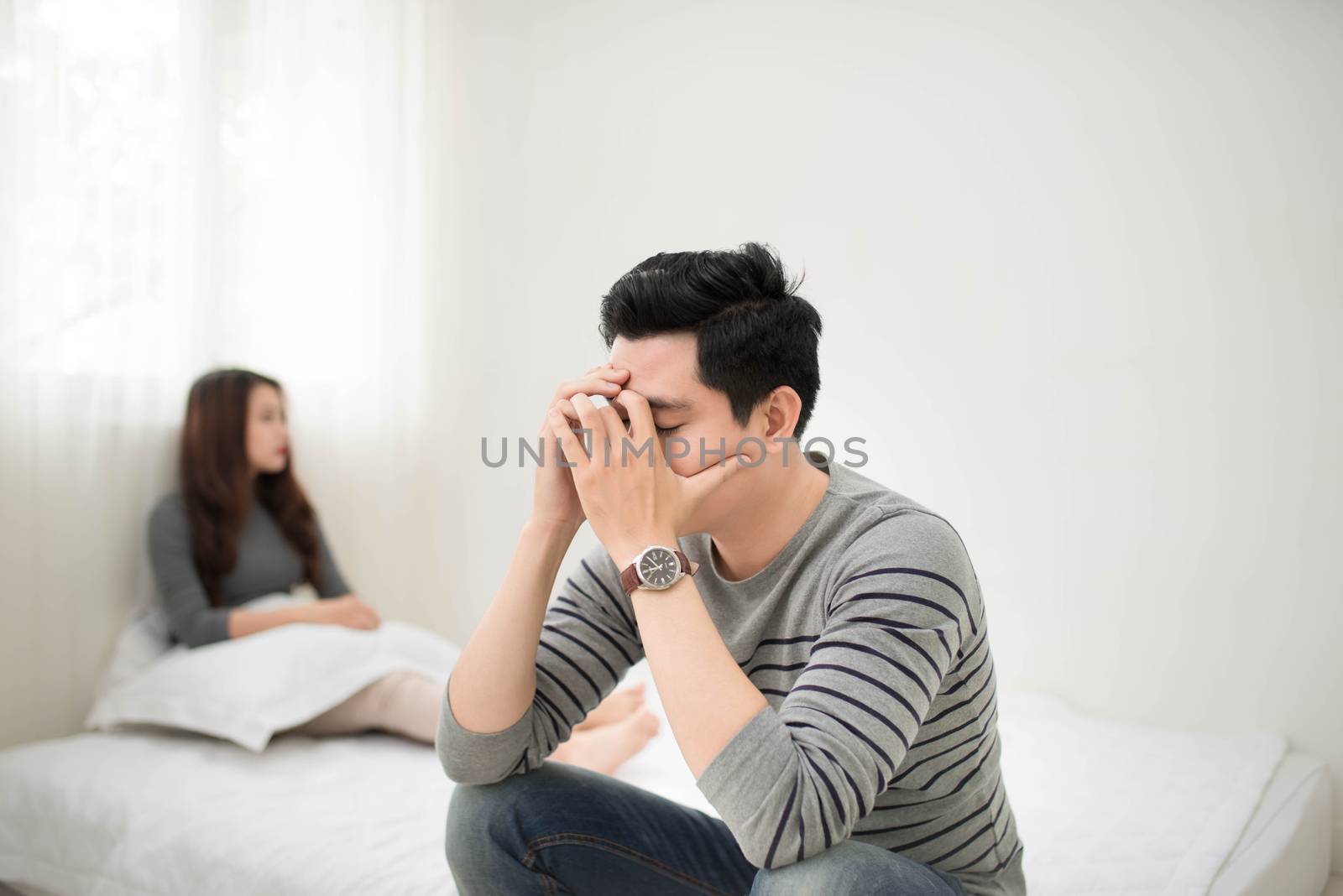 Sad asian couple mad at each other in their living room